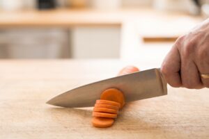 Faca de chef cortando uma cenoura